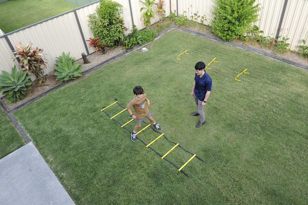 Physiotherapist guiding a client through a balance and mobility exercise outdoors