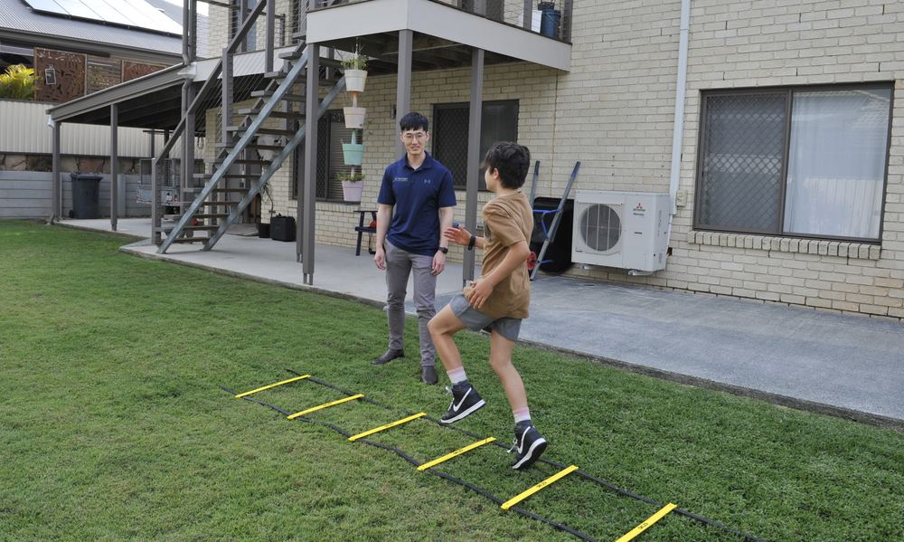 Physiotherapist supporting a child through an active movement task
